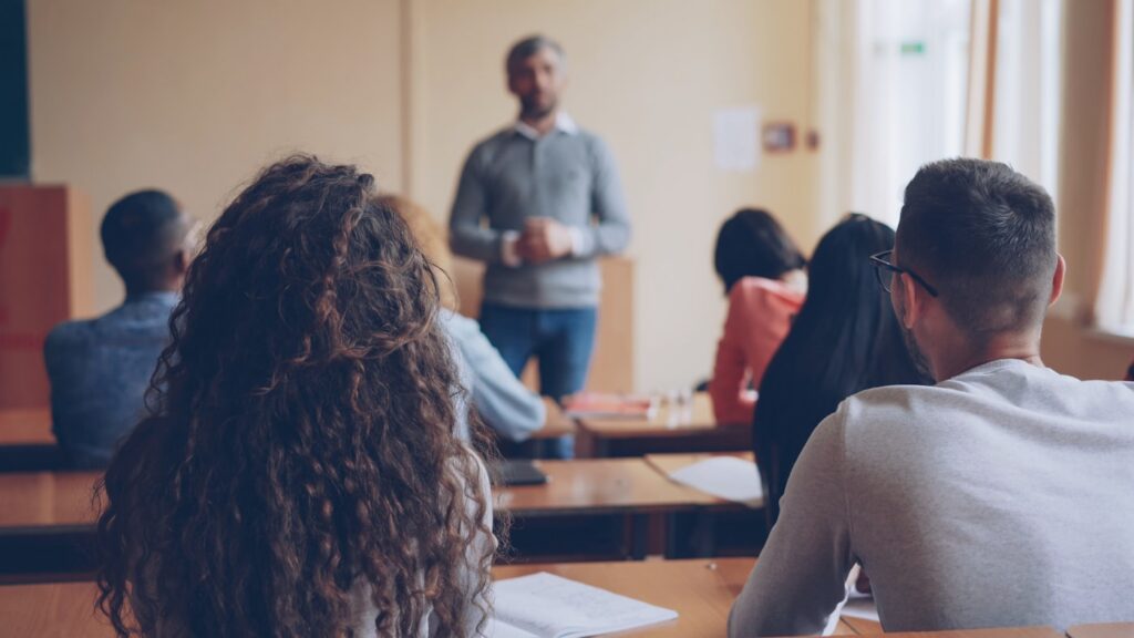 Lehrkraft unterrichtet eine Gruppe von Schülerinnen und Schülern im Klassenraum